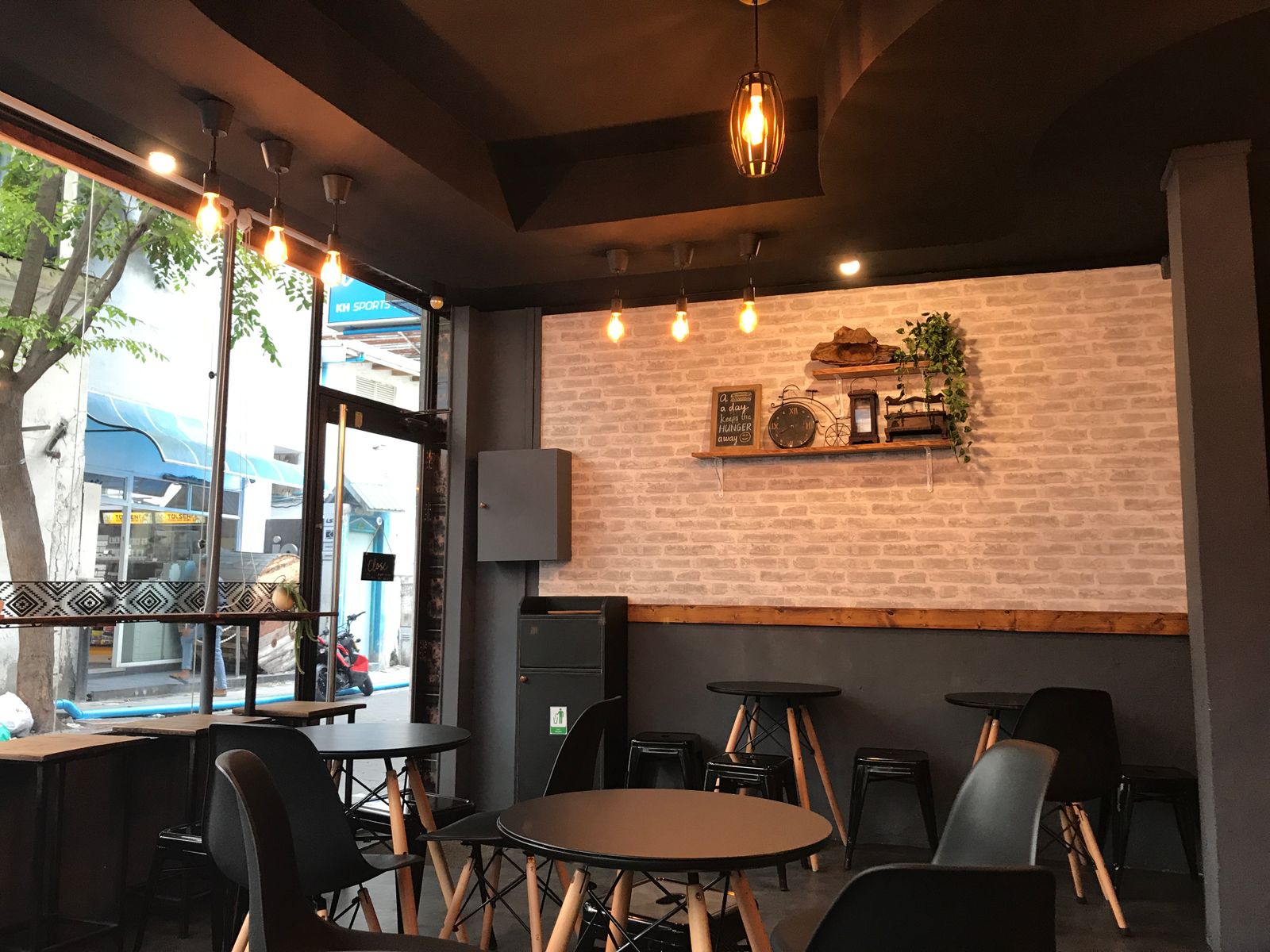 The interior of a small neighbourhood cafe with warm hanging lights